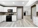 Modern kitchen with white cabinets, stainless steel appliances, granite countertops, and decorative backsplash at 7490 Locust Ne St, St Petersburg, FL 33702