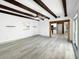 Open-concept living space featuring wood beams, ceiling fan and modern flooring at 7490 Locust Ne St, St Petersburg, FL 33702