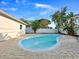 Backyard features a kidney-shaped pool surrounded by a brick paver deck and lush landscaping at 7490 Locust Ne St, St Petersburg, FL 33702