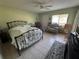 Spacious bedroom with a wrought iron bed frame, tile floors and natural light from the windows at 129 Caryl Way # 129, Oldsmar, FL 34677