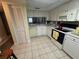 Cozy kitchen featuring white cabinets, tile floors, and essential appliances at 129 Caryl Way # 129, Oldsmar, FL 34677