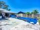 Backyard with in-ground pool covered in a blue tarp, large patio area, and fencing at 1369 Brookside Dr, Venice, FL 34285