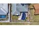 Aerial view of a backyard featuring a covered pool, fenced yard, and grass at 1369 Brookside Dr, Venice, FL 34285