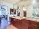 Bathroom features dual sinks, large mirror, doorway to closet, and entryway to bedroom at 1369 Brookside Dr, Venice, FL 34285