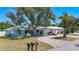 Charming single-story home with a spacious driveway, mature trees, and lush lawn at 1369 Brookside Dr, Venice, FL 34285