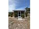 Inviting backyard featuring rock beds, lush greenery, and a screened-in lanai entrance at 22227 Elmira Blvd, Port Charlotte, FL 33952