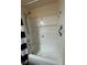Clean, white tiled shower and bathtub with shower head and safety bars at 22227 Elmira Blvd, Port Charlotte, FL 33952