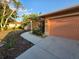 Well-maintained home exterior with a tidy lawn, attractive landscaping, and a driveway leading to an attached garage at 22227 Elmira Blvd, Port Charlotte, FL 33952