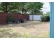 Landscaped backyard featuring an outdoor seating area, enclosed by a brick wall and white fence for privacy at 32618 Rapids Loop, Wesley Chapel, FL 33545