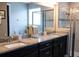 Spacious bathroom boasts double vanities, granite counters, a glass-enclosed shower, and a soaking tub at 32618 Rapids Loop, Wesley Chapel, FL 33545