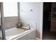 Relaxing bathtub area offers a tranquil space with tiled surround, natural light, and a view into the closet at 32618 Rapids Loop, Wesley Chapel, FL 33545