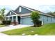 Lovely single-story home featuring a manicured lawn and a light blue two-car garage at 32618 Rapids Loop, Wesley Chapel, FL 33545