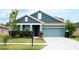 Charming single-story home with a well-manicured lawn and a light blue two-car garage at 32618 Rapids Loop, Wesley Chapel, FL 33545
