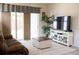 Comfortable living room with a plush sofa, entertainment center, and sliding glass doors to the backyard at 32618 Rapids Loop, Wesley Chapel, FL 33545