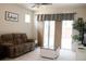 Inviting living room with a cozy sofa, modern decor, and sliding doors that offer access to outdoor living at 32618 Rapids Loop, Wesley Chapel, FL 33545