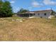 An exterior view of the home's backyard featuring a screened-in porch and white exterior at 38832 Henry Dr, Zephyrhills, FL 33542