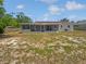 An exterior view of the home's backyard featuring a screened-in porch and partial grass at 38832 Henry Dr, Zephyrhills, FL 33542