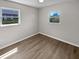 Bright bedroom with luxury vinyl plank flooring and two windows at 38832 Henry Dr, Zephyrhills, FL 33542