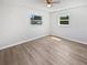 Bright bedroom featuring hardwood floors, two windows, and a ceiling fan at 38832 Henry Dr, Zephyrhills, FL 33542