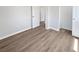 Bedroom features wood-look flooring, neutral paint, closet, and doorways at 38832 Henry Dr, Zephyrhills, FL 33542