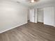 Bedroom features wood-look flooring, neutral paint, ceiling fan, closet, and doorway at 38832 Henry Dr, Zephyrhills, FL 33542