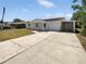 Charming single-story home features a quaint front porch, attached garage, and large driveway at 38832 Henry Dr, Zephyrhills, FL 33542