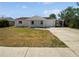 Charming single-story home features a quaint front porch, attached garage, and driveway at 38832 Henry Dr, Zephyrhills, FL 33542