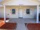 Inviting front porch features white columns, a front door, and mulched flower beds at 38832 Henry Dr, Zephyrhills, FL 33542