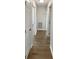 Hallway featuring multiple white doors and luxury vinyl plank flooring at 38832 Henry Dr, Zephyrhills, FL 33542