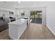 Modern kitchen featuring white cabinets, stainless steel appliances, a white quartz island, and sliding glass doors at 38832 Henry Dr, Zephyrhills, FL 33542