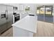 Bright kitchen with stainless steel appliances, white cabinets, subway tile backsplash, and a large white quartz island at 38832 Henry Dr, Zephyrhills, FL 33542
