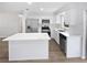 Well-lit kitchen featuring stainless steel appliances, white cabinets, quartz countertops and a kitchen island at 38832 Henry Dr, Zephyrhills, FL 33542