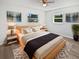 Comfortable main bedroom featuring soft, neutral décor, modern wall art, and light-colored wood-look flooring at 38832 Henry Dr, Zephyrhills, FL 33542