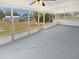 Enclosed sunroom with large screened windows, concrete flooring, and a ceiling fan at 38832 Henry Dr, Zephyrhills, FL 33542