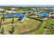 Aerial view of a community park featuring a basketball court, playground, and picnic area, surrounded by lush greenery at 16231 Pine Mist Dr, Bradenton, FL 34211