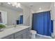 Bathroom featuring a single vanity with stone countertops and a tiled shower with blue curtain at 16231 Pine Mist Dr, Bradenton, FL 34211