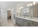 Bathroom featuring double sink vanity with stone countertops, a large mirror, and tiled floors at 16231 Pine Mist Dr, Bradenton, FL 34211