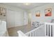 Bedroom featuring neutral colors, crib, sliding door closet, and decorative accents at 16231 Pine Mist Dr, Bradenton, FL 34211
