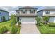 Charming two-story home with a well-maintained lawn, featuring a brick driveway and an attached two-car garage at 16231 Pine Mist Dr, Bradenton, FL 34211
