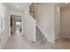 Bright foyer with tile flooring, a staircase with carpeted steps, and neutral walls, creating an open and welcoming entrance at 16231 Pine Mist Dr, Bradenton, FL 34211