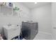 Functional laundry room with utility sink, wire shelving, and modern gray washer and dryer at 16231 Pine Mist Dr, Bradenton, FL 34211