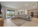 Spacious living room with tile flooring, a large sectional sofa, and sliding glass doors leading to the outdoor area at 16231 Pine Mist Dr, Bradenton, FL 34211