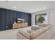 Stylish living room featuring a dark accent wall, comfortable seating, and sliding glass doors for natural light and access to the outdoors at 16231 Pine Mist Dr, Bradenton, FL 34211