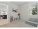 Bright playroom with a comfy gray couch, storage shelves, and natural light from the window at 16231 Pine Mist Dr, Bradenton, FL 34211