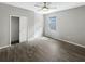 Bedroom showcasing window views, wood-style flooring, and a closet with a door at 19664 Ship Wheel Way, Land O Lakes, FL 34638