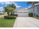Charming home featuring a two-car garage, well-manicured landscaping, and a welcoming front entrance at 3319 Thistledown Ln, Land O Lakes, FL 34638