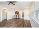 Open-concept living area with hardwood floors, arched doorways, and easy access to the kitchen at 3319 Thistledown Ln, Land O Lakes, FL 34638