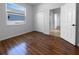 Bedroom with wood floors and a view of the yard through a large window at 6370 Sturbridge Ct, Sarasota, FL 34238