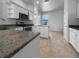 Kitchen featuring white cabinetry, tiled floors and granite countertops at 6370 Sturbridge Ct, Sarasota, FL 34238