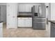 Galley kitchen features stainless steel refrigerator, white cabinets, and granite counters at 6370 Sturbridge Ct, Sarasota, FL 34238